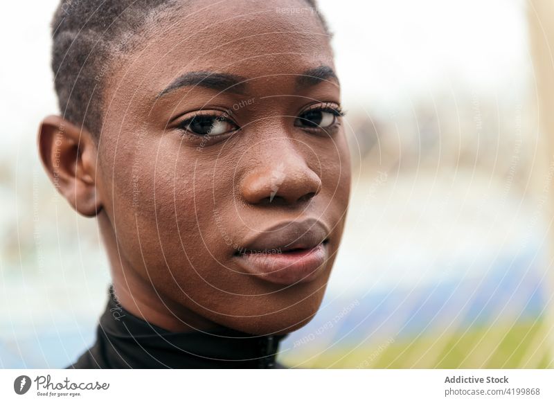 Sanfte schwarze Frau in Freizeitkleidung im Stadtpark feminin sanft Kurze Haare Angebot herzlich freundlich charmant angenehm Park Porträt urban Rasen anhaben