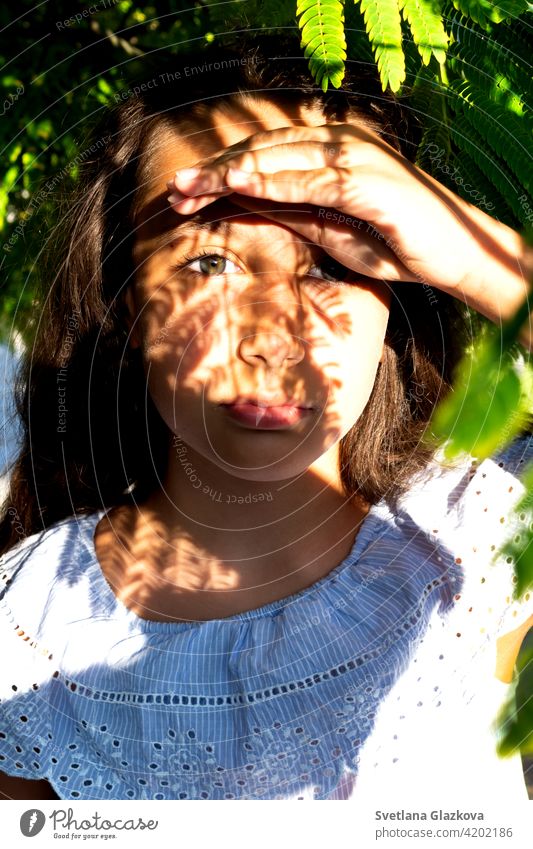 Spiel von Licht und Schatten Porträt eines schönen gebräunten kaukasischen niedlichen Mädchen in der tropischen Grünanlage. Reisen, Urlaub, warme Länder. Frau