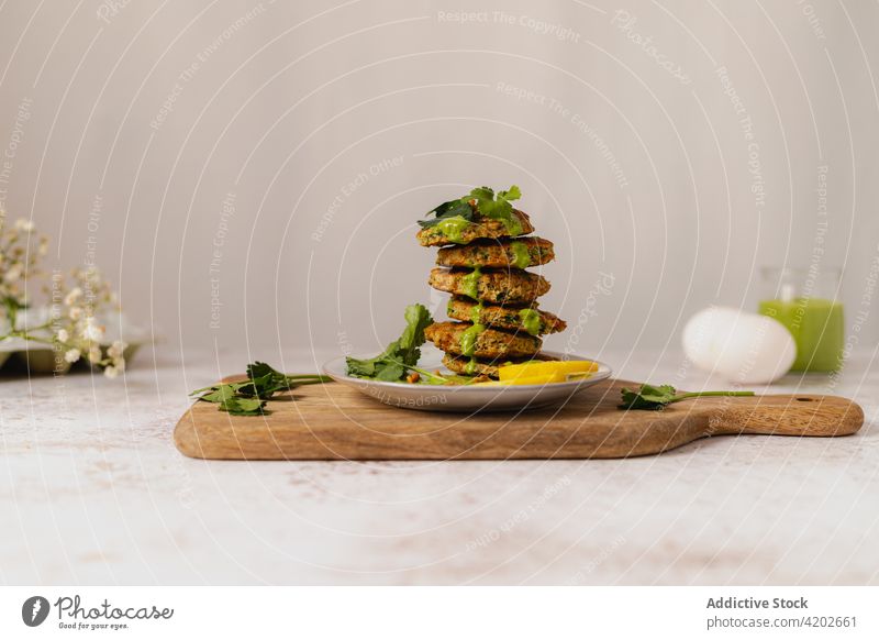 Leckere Gemüsekrapfen auf einem Teller auf einem Holzbrett gestapelt Fritter Kräuterbuch appetitlich Stapel Vegetarier Küche dienen Speise Garnierung