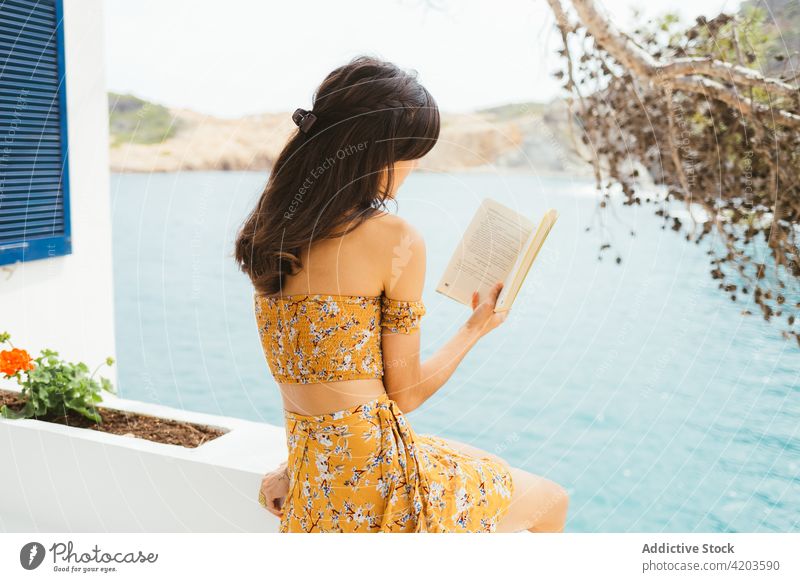 Junge Frau liest Buch in der Nähe eines Sees lesen Sommer Terrasse Landschaft ruhen genießen romantisch Windstille jung Wasser Roman Sommerzeit Etage Literatur