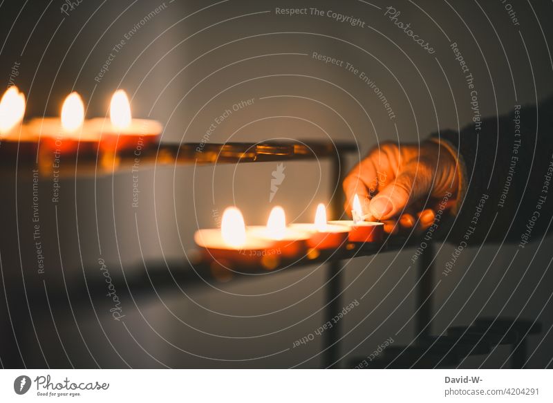 anzünden von Teelichtern in der Kirche Kerzen Hand Streichholz leuchten ruhe Glaube gedenken Religion beten brennen stille brennend Licht