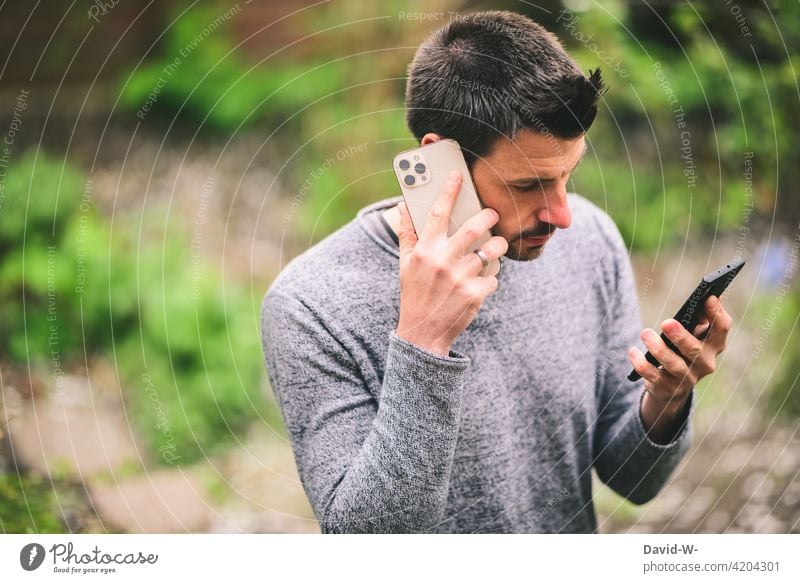 Mann mit zwei Smartphones Handys benutzen mobile telefonieren Technik & Technologie digital Internet Lifestyle suchen