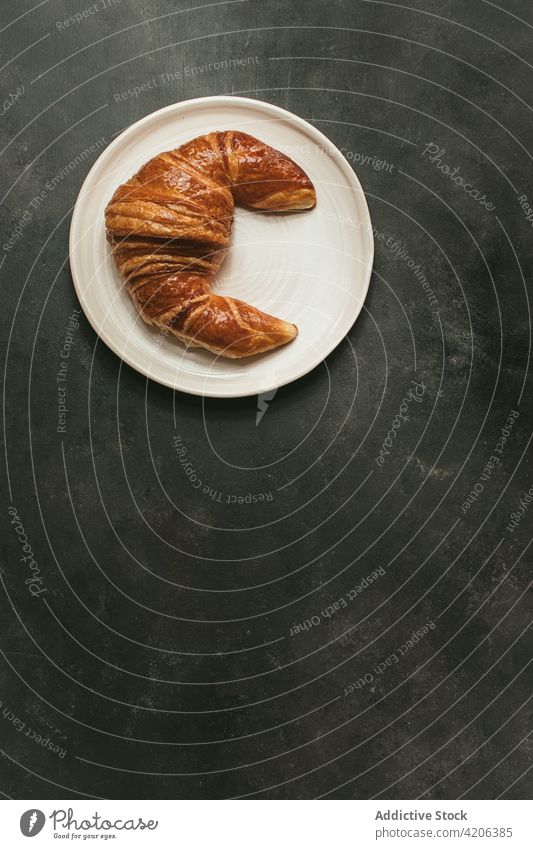 Gebackenes Croissant auf einem Teller auf dem Tisch gebacken Brot Kulisse Lebensmittel frisch Bäckerei Brötchen Gebäck Frühstück Form Küche Ernährung Kruste