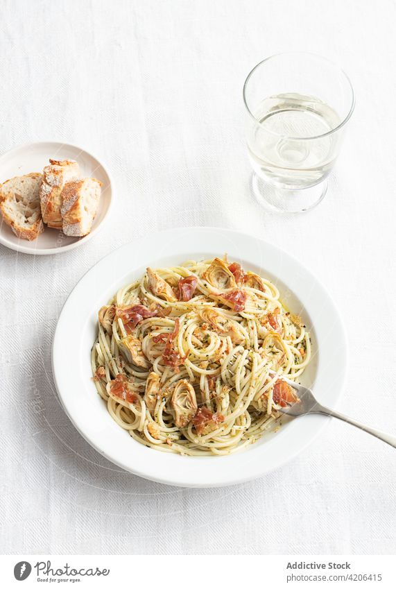 Nahaufnahme eines Tellers mit Spaghetti und Artischocken von oben gesehen Lebensmittel frisch Käse Paprika Schinken Gemüse Spätzle Prosciutto Vegetarier