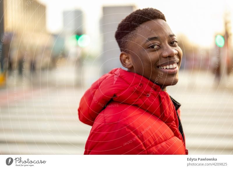 Porträt eines jungen Mannes, der auf einer Straße in der Stadt steht und lächelt schwarz außerhalb urban tausendjährig Stehen Afrikanisch im Freien Großstadt