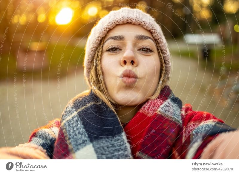 Selbstporträt einer verspielten jungen Frau im Freien tausendjährig auflehnen Behaarung Zopf urban Großstadt Straße Teenager trendy cool warme Kleidung Winter