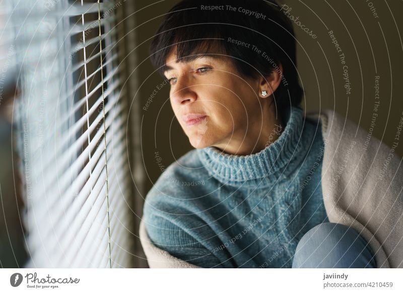 Glückliche Frau mittleren Alters mit nostalgischem Blick, während sie aus dem Fenster blickt. heimwärts 50s Nostalgie besinnlich nachdenklich Denken 40s Person