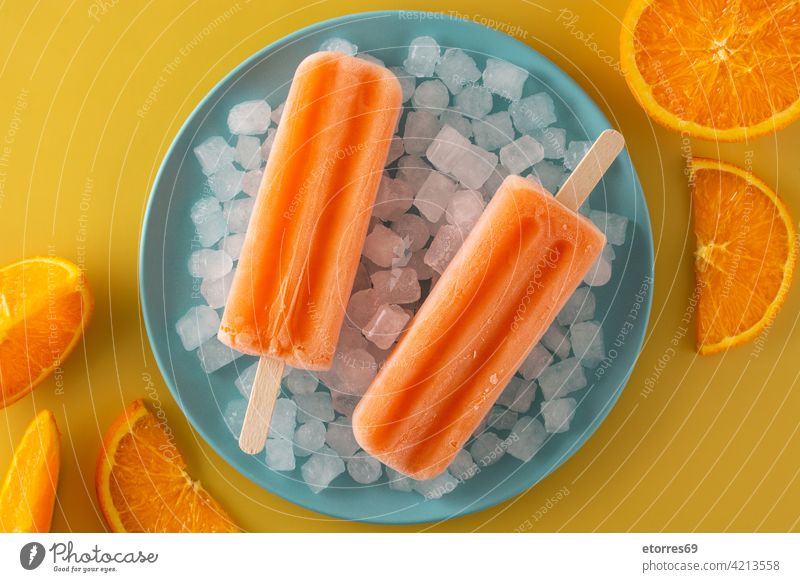 Orange Eis am Stiel auf blauem Teller Hintergrund Kuchen kalt farbenfroh cool Sahne Dessert Geschmack Lebensmittel frisch frostig gefroren Frucht selbstgemacht
