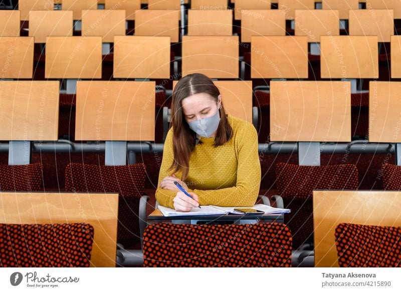Studentin sitzend mit Gesichtsmaske Bildung Schüler Klassenraum studierend zurück zur Schule Gymnasium Lernen Sicherheit Frau Person im Innenbereich Schutz