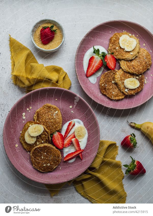 Mit Bananenpfannkuchen und ein paar Erdbeerstücken belegen Dessert süß Frühstück Lebensmittel Erdbeeren Zucker Sahne selbstgemacht Amerikaner lecker Pfannkuchen