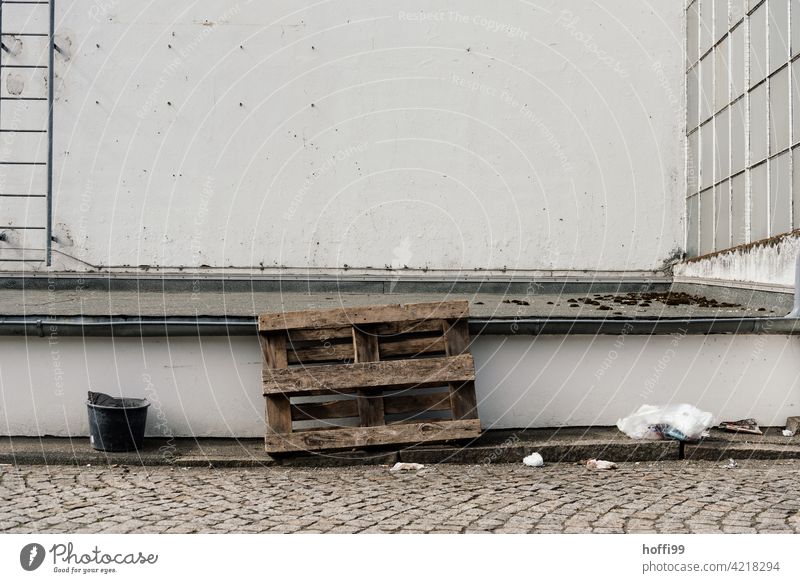 Palette mit Einem und Abfall auf einem Hinterhof Eimer Hinterhofwerkstatt Müll dreckig entsorgen wegwerfen grau trist Tristesse Reste vergessen Verfall