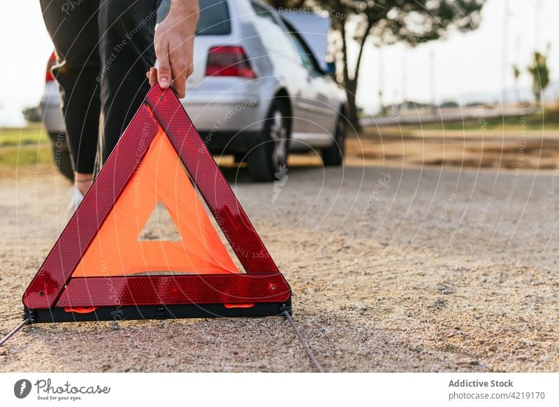 Fahrer stellt rotes Dreieck in der Nähe des kaputten Autos auf PKW gebrochen Zeichen Notfall Verkehr Problematik Ermahnung Straße Fahrzeug Automobil Panne