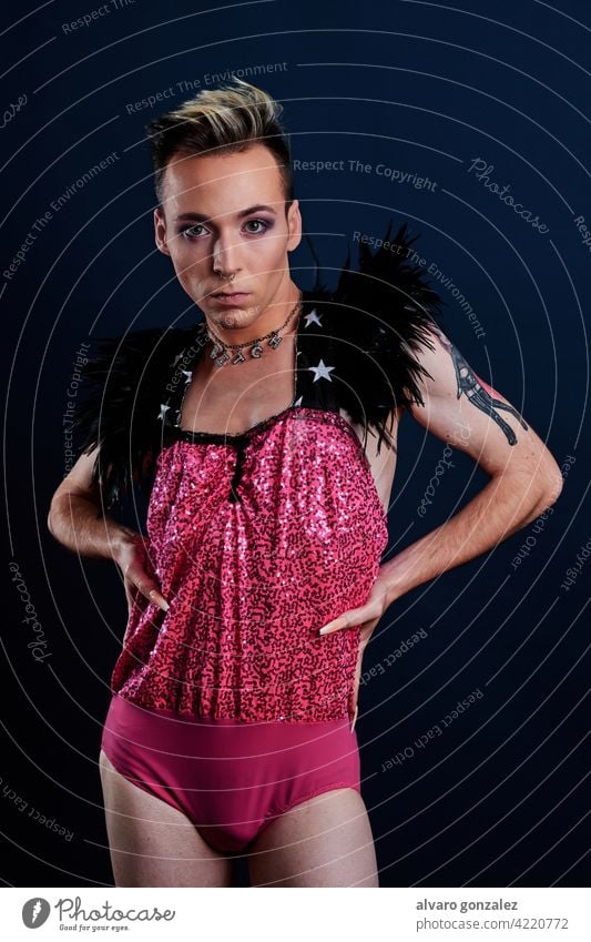 Junge Transgender-Modell mit rosa Kleid und dunkelblauem Hintergrund che Homosexualität Vielfalt feminin Porträt jung Typ Schminke männlich Person Kaukasier