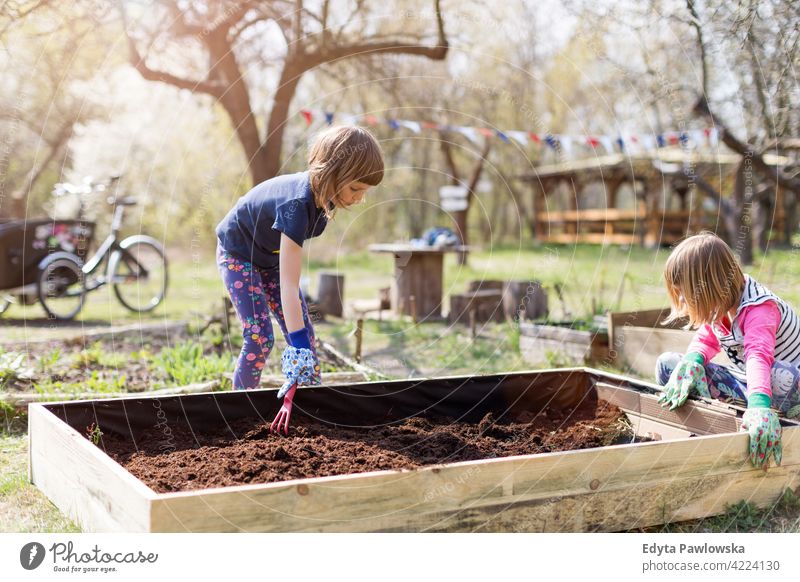 Zwei kleine Mädchen bei der Gartenarbeit im städtischen Gemeinschaftsgarten Bewässerung Gießkanne Wasser städtischer Garten Umweltschonung