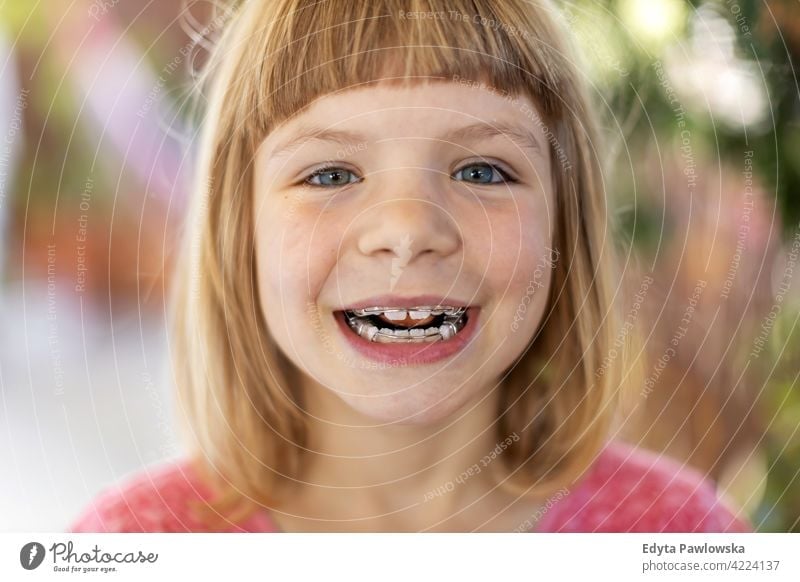 Porträt eines lächelnden kleinen Mädchens mit Zahnspange zahnfarben Zähne dental Zahnarzt Hygiene Pflege Kind Lächeln Glück jung niedlich wenig Gesicht Kindheit