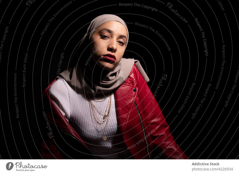 Stilvolle muslimische Frau in schwarzem Studio stehend Kopftuch Outfit modisch Mode selbstbewusst schick Kleidungsstück Körperhaltung Kultur Vorschein Model