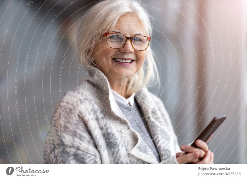 Porträt einer älteren Frau, die ein Mobiltelefon benutzt Brille Glück Lächeln genießend entspannt Positivität selbstbewusst natürlich Senior Senioren Rentnerin