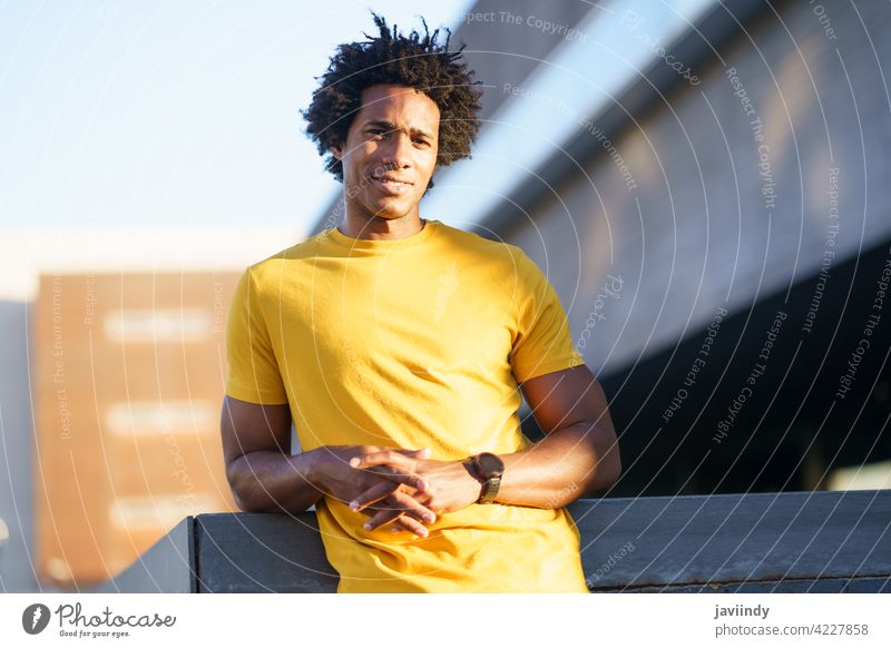 Schwarzer Mann mit Afro-Haar nimmt eine Pause nach dem Training. Fitness schwarz ruhen anstrengen Läufer Übung Jogger männlich Sport außerhalb copyspace Typ