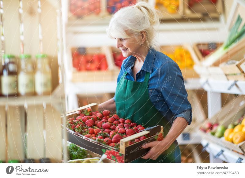 Ältere Frau arbeitet in einem kleinen Lebensmittelladen Lebensmittelhändler Gemüsehändler Lebensmittelgeschäft Menschen Senior reif Erwachsener lässig attraktiv