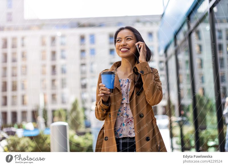 Junge Frau mit Smartphone und Kaffee in der Stadt Filipinos urban Straße Großstadt aktiv Menschen junger Erwachsener lässig attraktiv Glück asiatisch genießend