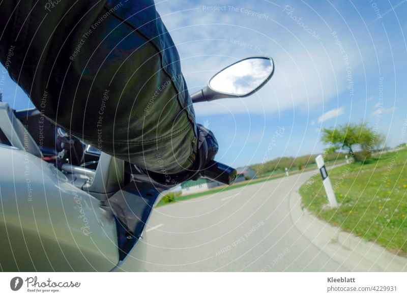 Kurvenlust - Kurvenfahrt auf einem Motorrad aus der Sicht des Sozius bei schönem Frühlingswetter Motorrad fahren Motorradfahrer Teilausschnitt Hand am Lenker