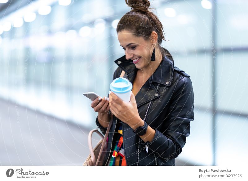 Junge Frau mit Smartphone in einer städtischen Umgebung urban Straße Großstadt aktiv Menschen junger Erwachsener lässig attraktiv Glück Kaukasier genießend