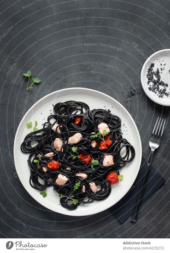 Spaghetti mit schwarzer Tinte und Lachs Kirschtomaten schwarze Nudeln schwarze Spaghetti italienische Spaghetti Essen kulinarisch Basilikum Mahlzeit