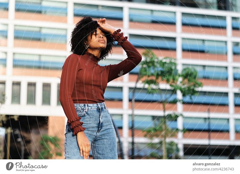Afro-Frau steht im Freien auf der Straße. jung Afro-Look schwarz urban Porträt Mode Großstadt lockig Behaarung laufen Kleidung außerhalb Hintergrund Stil