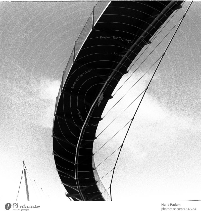 Ein Bogen schwingt sich auf analog Analogfoto sw Schwarzweiß Brücke Erzbahnschwinge Fußgängerbrücke Architektur Pylone Stahl Seile Stahlseile Froschperspektive