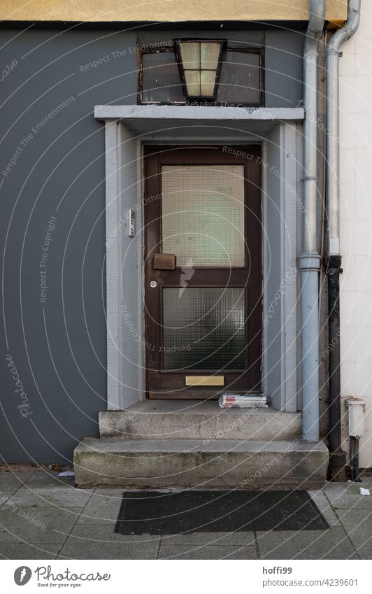 monoton trister Hauseingang mit Altpapier auf den Stufen Eingang Eingangsbereich Briefkasten Leerstand verlassen Tristesse geschlossen Geschäftsausgabe Treppe