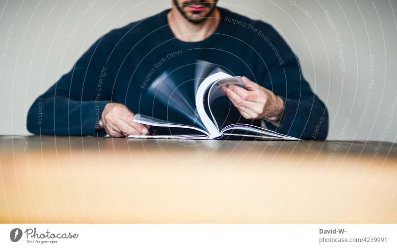 Mann blättert in einem Buch blättern Nachschlagen lesen Bildung lernen Tisch sitzen anonym Buchseiten Wissen