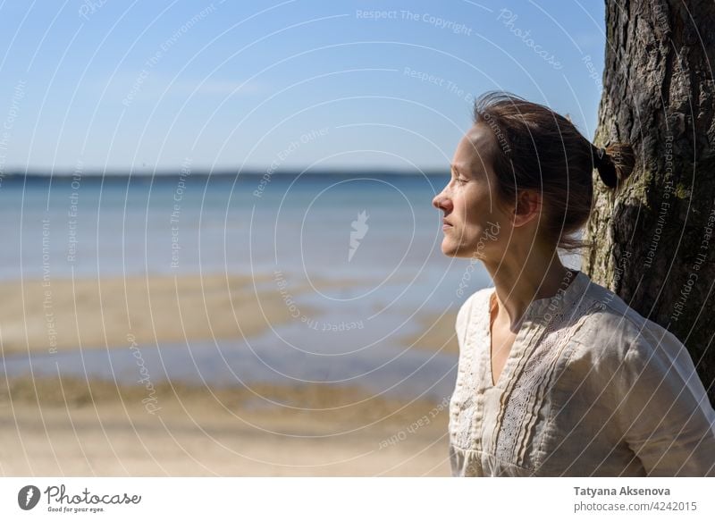 Frau sitzt zwischen Bäumen und schaut auf das Meer Natur im Freien Wohlbefinden Erholung Achtsamkeit sich[Akk] entspannen Atmung MEER Ruhe Meditation Person