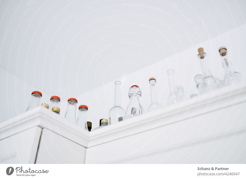 Sammlung von leeren Flaschen auf dem Küchenschrank Glasflaschen sammeln gereinigt einkochen abfüllen Lebendmittel verarbeiten weiß aufheben Korken Vasen