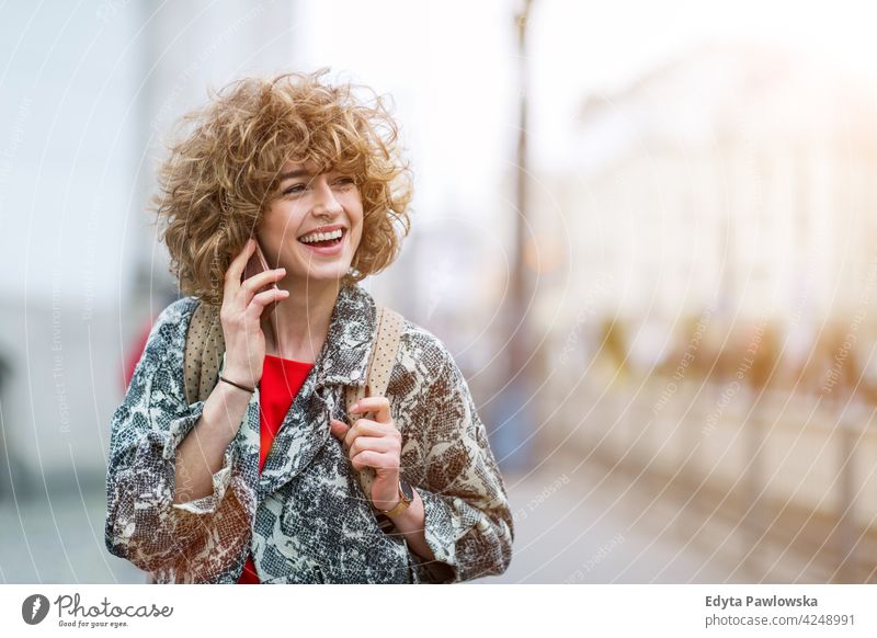 Porträt einer jungen Frau, die ein Mobiltelefon benutzt genießend Lifestyle Erwachsener Menschen eine Person lässig Kaukasier positiv sorgenfrei Glück Lächeln