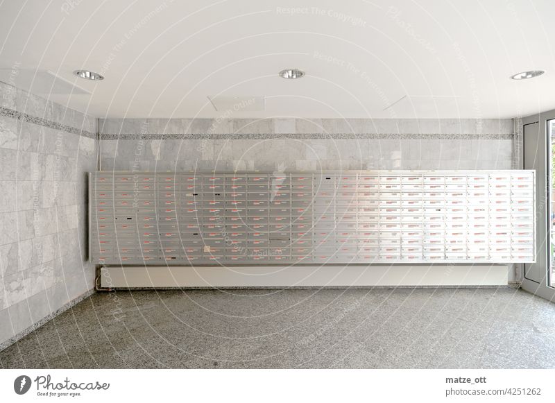 220 Briefkästen im Mehrfamilienwohnhaus Post Porto Briefkasten Versenden Werbung Postbote Briefträger Farbfoto Kommunizieren Menschenleer Wand Haus Metall