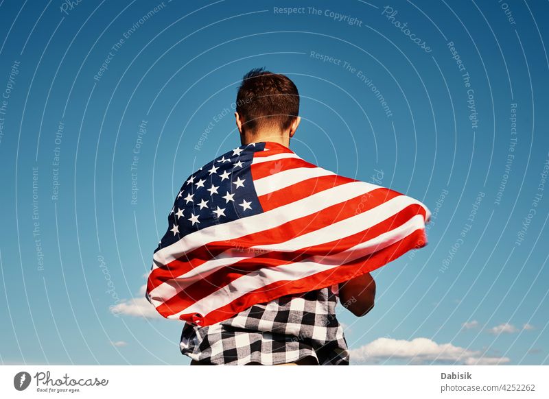 Mann hält usa Nationalflagge gegen blauen Himmel Fahne Amerikaner im Freien USA 4. Juli Person winkend Menschen Sommer Tag Stern streifen amerika Hintergrund