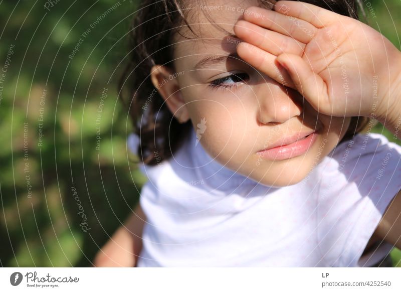 neugieriges Mädchen schaut in die Sonne und schützt ihre Augen mit der Hand zuschauend Überraschung spielerisch Person Blick Aussehen Lernen Kind Gesicht