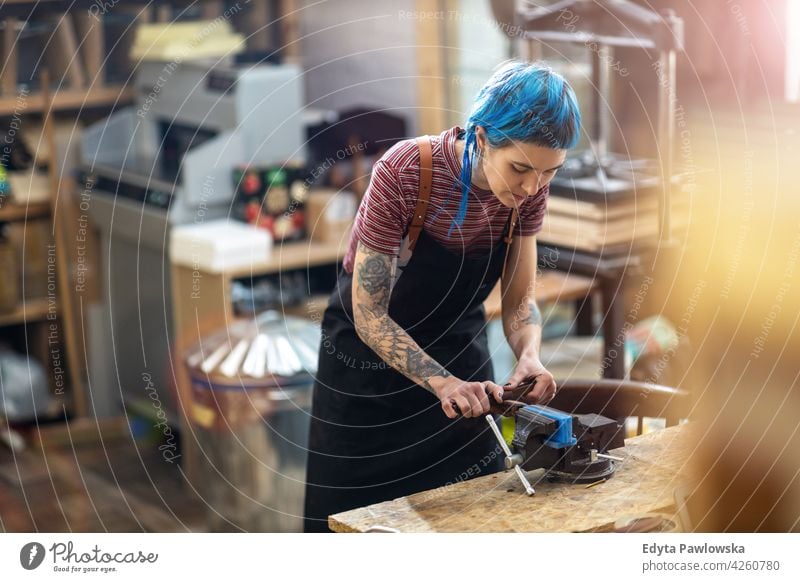 Junge Frau bei Holzarbeiten in einer Werkstatt diy Hipster Behaarung Tattoos Besitzer Beruf Dienst Kleinunternehmen Mitarbeiter Arbeitsplatz Flugzeugwartung