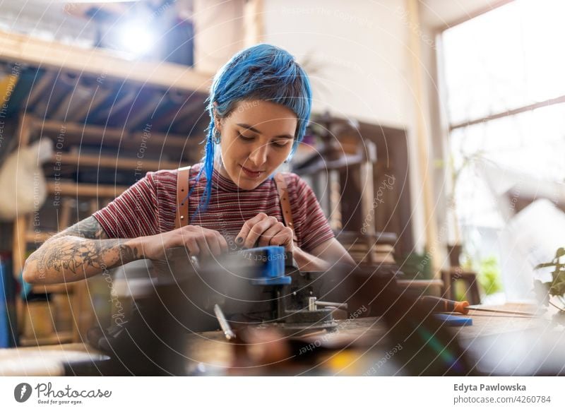 Junge Frau bei Holzarbeiten in einer Werkstatt diy Hipster Behaarung Tattoos Besitzer Beruf Dienst Kleinunternehmen Mitarbeiter Arbeitsplatz Flugzeugwartung