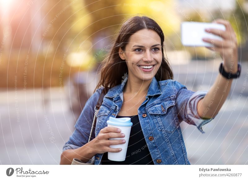 Junge Frau mit Smartphone und Kaffee in der Stadt urban Straße Großstadt aktiv Menschen junger Erwachsener lässig attraktiv Glück Kaukasier genießend