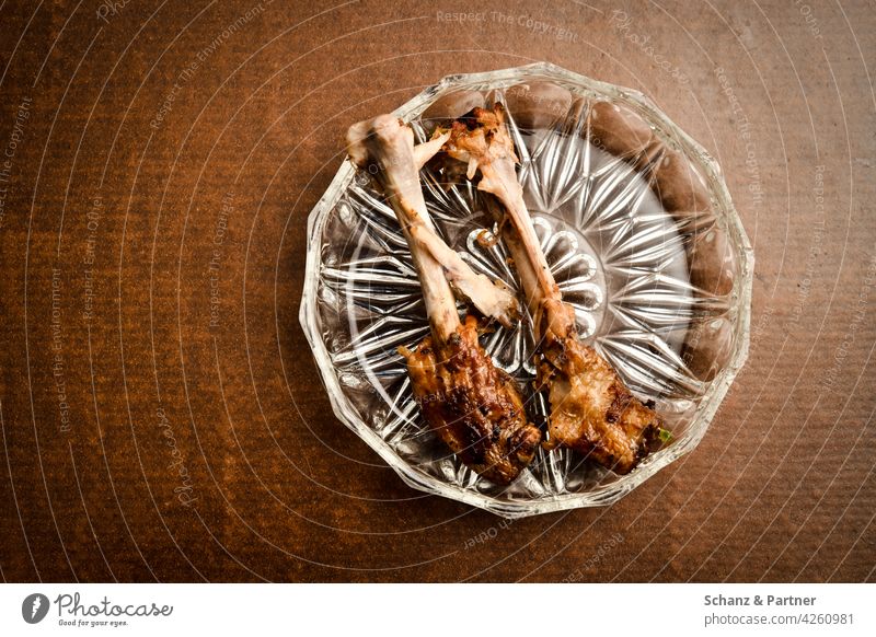 Hähnchenknochen auf einem geschliffenen Glasteller Essen abnagen Lebensmittel Reste Essensreste Ernährung Farbfoto Fleisch Bioprodukte Foodfotografie Küche