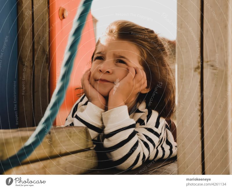 Porträt eines kaukasischen kleinen Mädchens mit den Händen auf dem Gesicht in einer nachdenklichen Haltung Unschuld Denken Ruhe Einsamkeit besinnlich