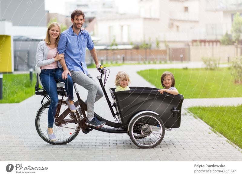 Junge Familie hat eine Fahrt mit Fracht Fahrrad Dreirad Lastenrad Tag Gesundheit Lifestyle aktiv im Freien Spaß Freude Zyklus Radfahren Aktivität Radfahrer