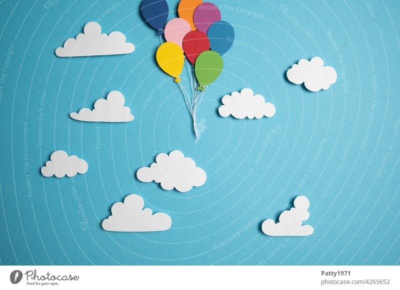 Aus Papier ausgeschnittene Luftballons schweben zwischen fluffigen Wolken durch den Himmel aus dem Bild herausl viele wolken aufsteigen verlassen fliegen