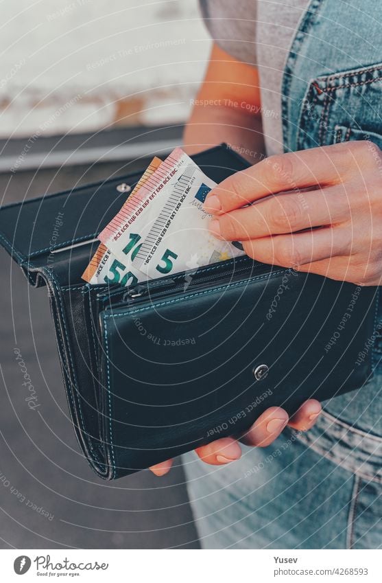 Weibliche Hände halten eine Brieftasche mit Euro-Banknoten. Das Konzept der Finanzen, Ersparnisse, finanzielle Ausgaben. Nahaufnahme. Vertikale Aufnahme Frau