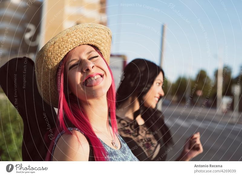 pinkhaarige Frau mit Hut streckt die Zunge in die Kamera jung attraktiv 20s Freude Menschen Person Jugend urban Frauen hübsch hübsche Menschen im Freien