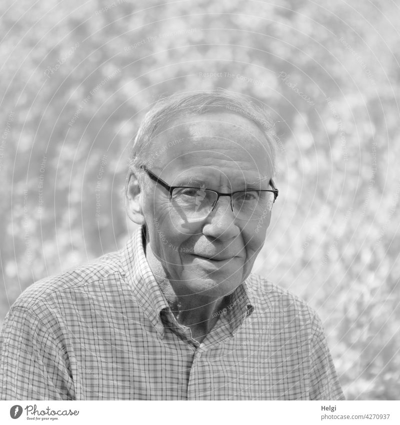 schwarz-weiß-Porträt eines freundlichen Senioren mit Brille in der Natur Mensch Mann Alter männlich Erwachsener reif alt Ruhestand Lächeln draußen lächelnd