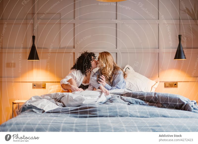 Lesbisches Paar umarmt und küsst sich im Bett Frauen lesbisch Kuss kuscheln Liebe Morgen Angebot Zuneigung lgbt gleichgeschlechtlich unkonventionell Geschlecht