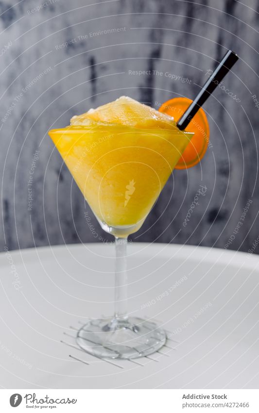 Glas mit exotischem Cocktail, Strohhalm und Orangenscheibe daikiri Zucker Rum Alkohol Passionsfrucht Kalk Saft dienen kalt Daikiri Maracuya trinken Scheibe