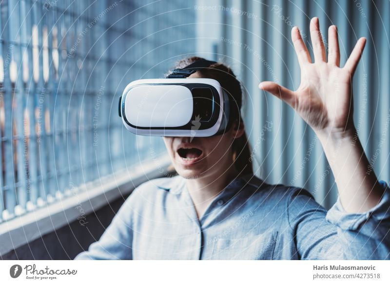 frau mit vr-brille und gesichtsausdruck genießt virtual-reality-erfahrung 3d Erwachsener Hintergrund lässig Kaukasier Großstadt Kreativität cyber Gerät digital